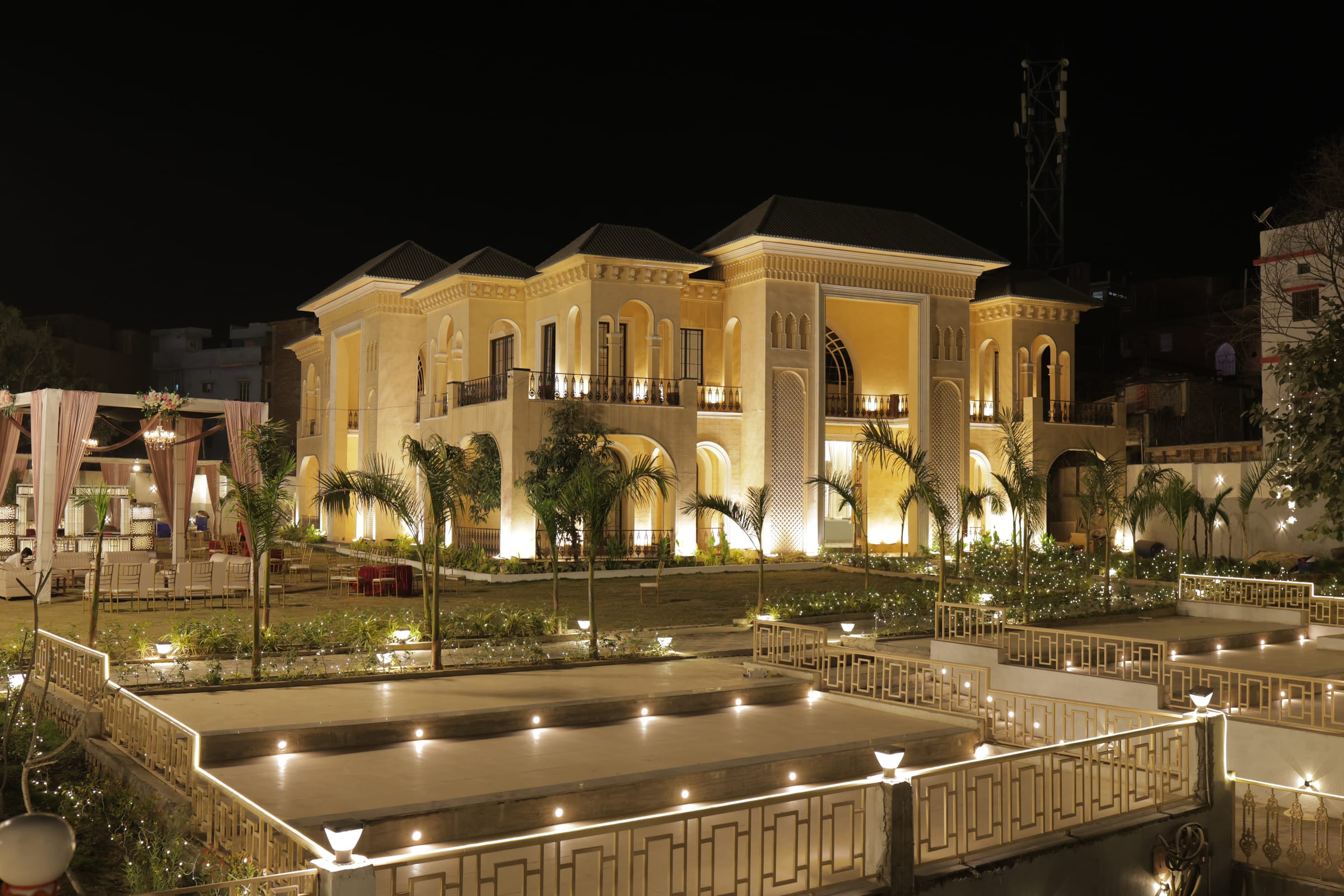 The venue exterior reflected in a lit pool at night