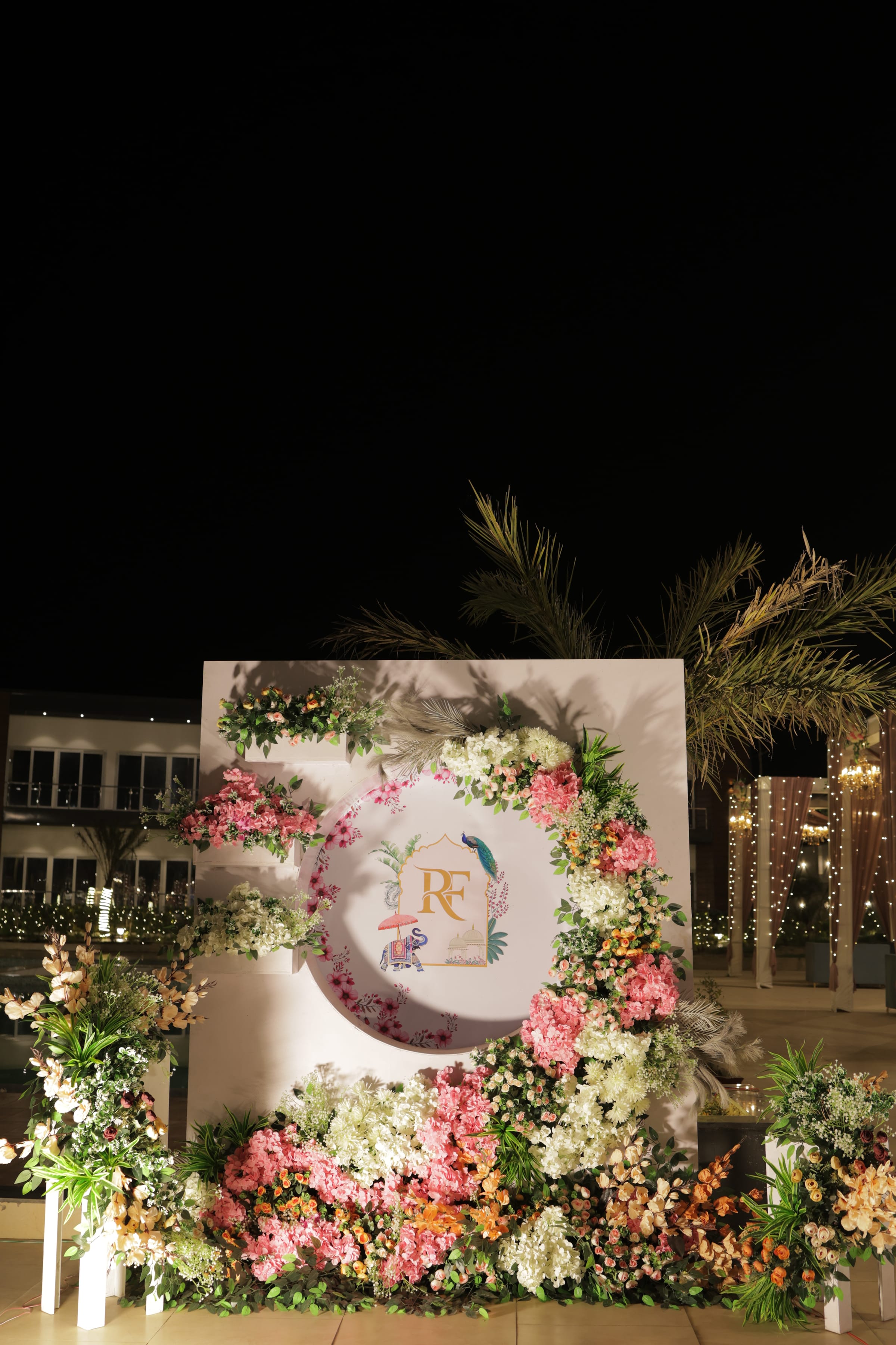 The monogrammed welcome board, close, surrounded by blooms